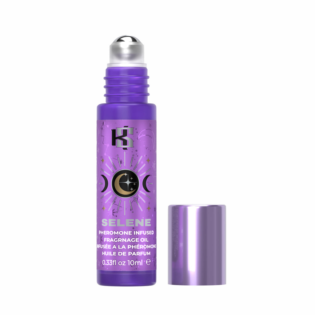 A purple roll-on perfume bottle labeled 'SELENE' with a silver cap, shown next to its matching metallic purple cap on a plain white background.