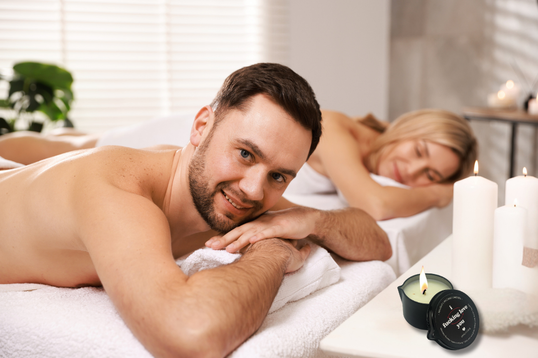 Man and woman lying on a bed with candles and plants in the background