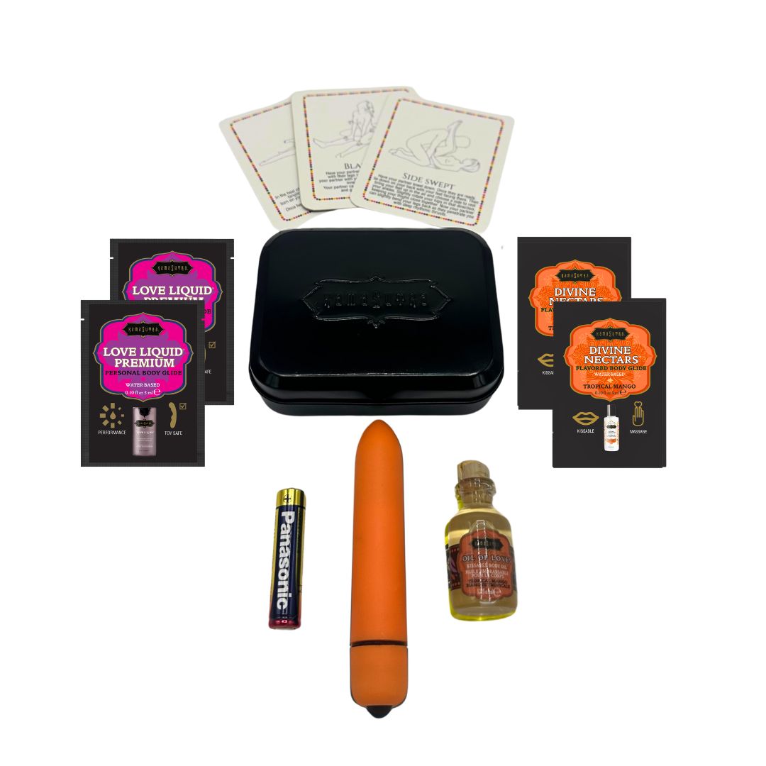 A photo showing the contents of the Kama Sutra weekender vibe kit in Tropical Mango. There is 3 position cards, 2 Love Liqud packets, two divine nectar Tropical Mango packets, an orange bullet vibe with battery and a mini glass Oil of Love outside a black tin.