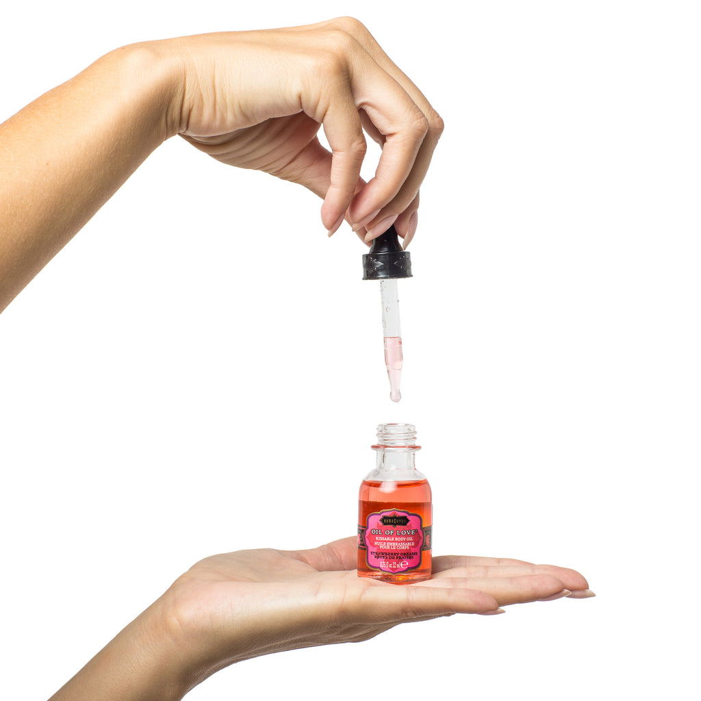 Oil of Love Strawberry with dropper applicator shown  in models hand - The Kama Sutra Company