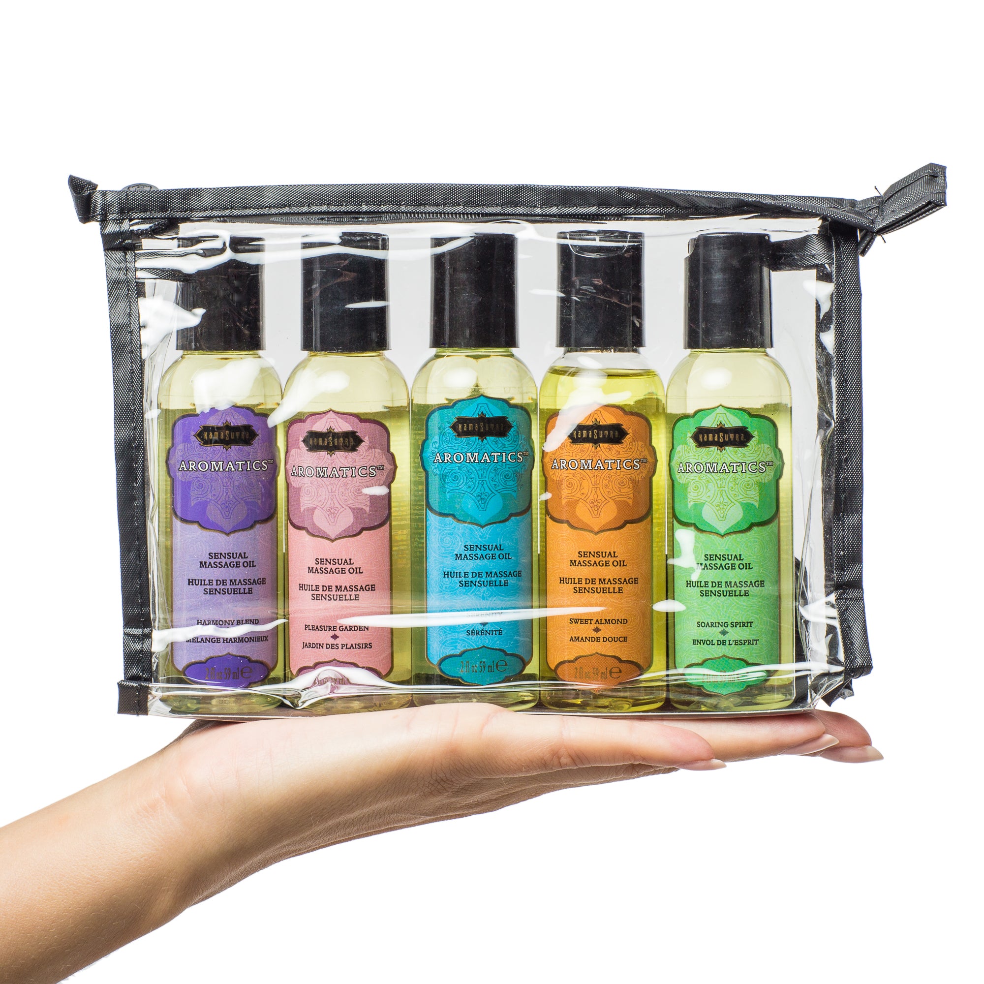 Massage Tranquility Kit shown in clear zipper travel bag with 6 scented massage oils in models hand- The Kama Sutra Company