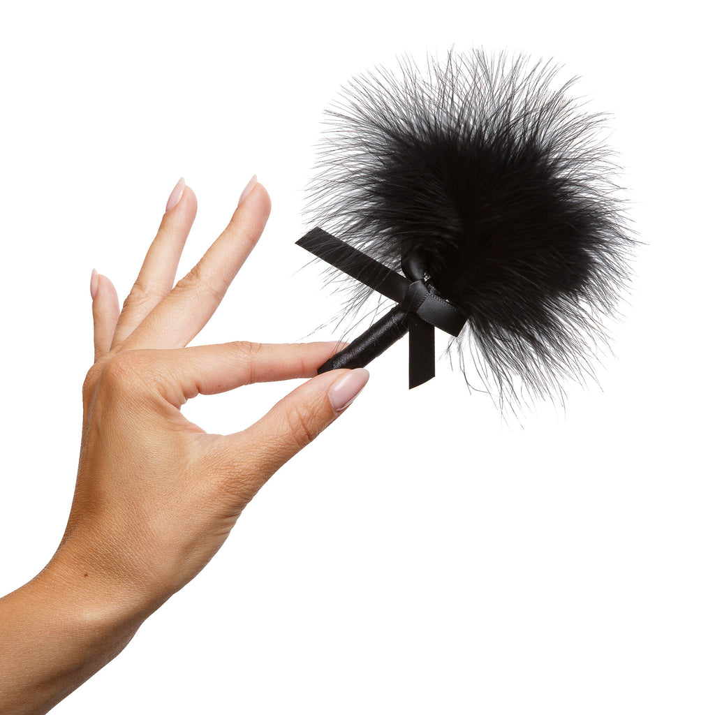 photo of black feather duster  in models hand