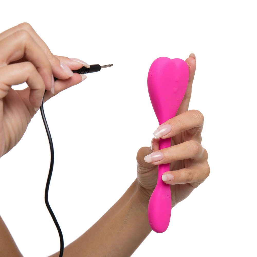 Natya  couples toy in models hands shown in pink demo how charger works- The Kama Sutra 